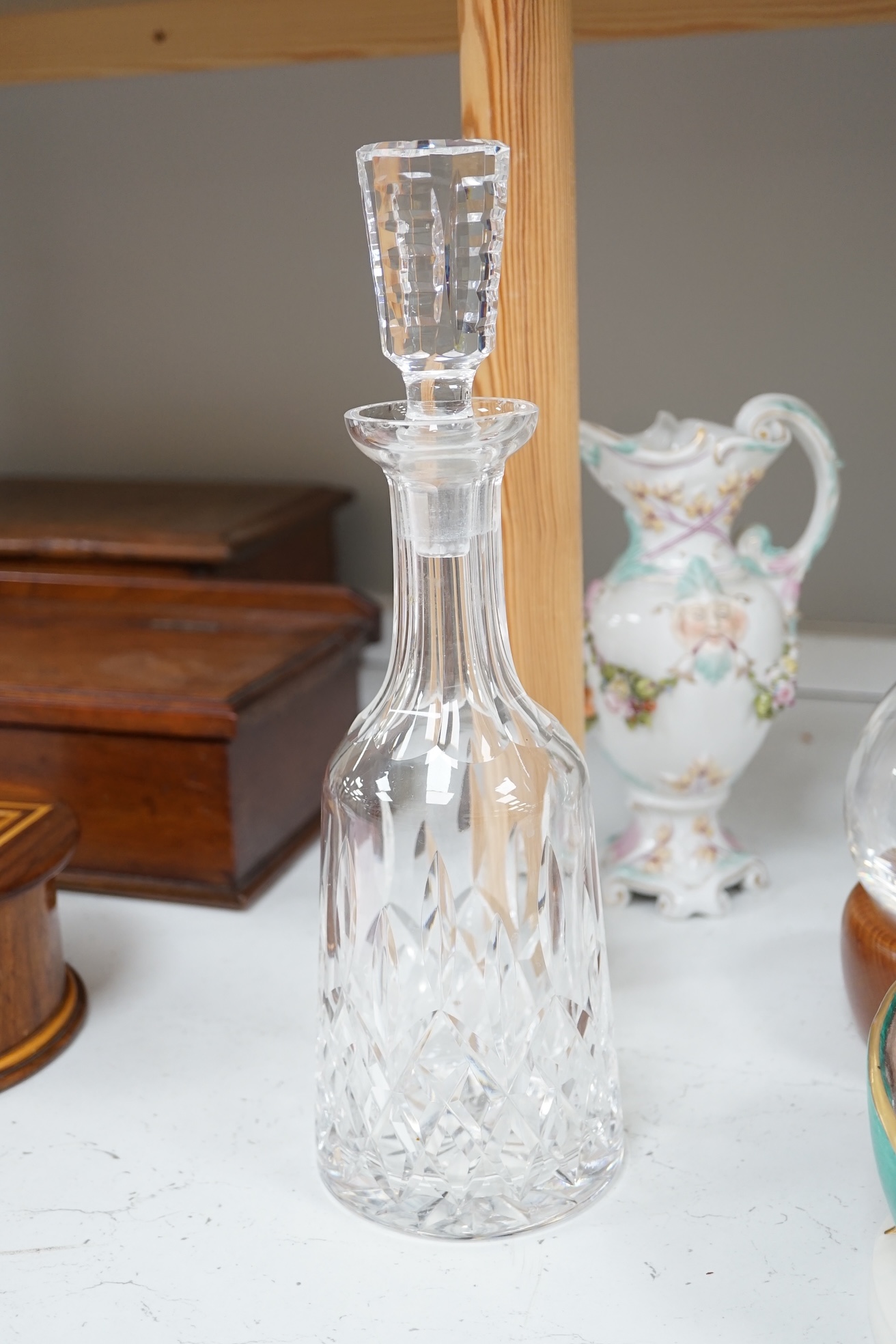 A collection of glassware and ceramics comprising Waterford decanter, two other decanters, German porcelain, ewers and a figure group, largest 40cm high. Condition - varies